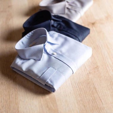 various men's dress shirts and slacks positioned over a white hardwood floor. clipart