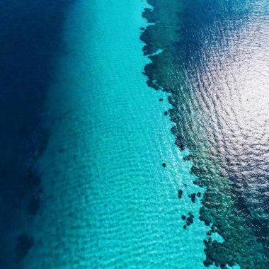 an aerial shot of a large, open ocean with a series of strikingly geometric patterns created by ocean currents and waves. Use varying shades of blue and green to highlight the patterns and depth clipart