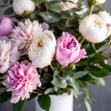 A close-up of a wedding bouquet composed of soft pink peonies and eucalyptus, with the intricate textures and colors of the flowers beautifully displayed against a blurred background clipart