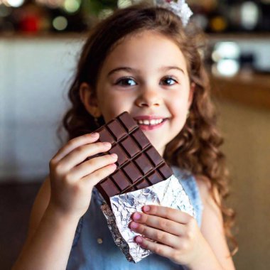 bar of chocolate in kid hands, blurred background clipart