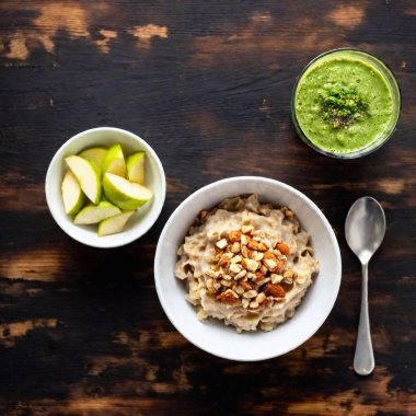 A balanced breakfast spread featuring overnight oats with almond butter, sliced apples, and a side of mixed nuts, served with a glass of green smoothie clipart