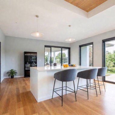 Long Shot of a Stylish Open-Concept Kitchen with a Dining Area: A low-angle photo of a stylish open-concept kitchen leading to a dining area. Shallow focus highlights the kitchen island, while the dining area is gently blurred in the background. clipart