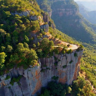 A full shot bird's-eye view of a dramatic mountain cliffside, with deep focus on the sheer drop and the landscape below. clipart