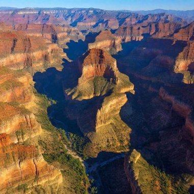 A full shot birds-eye-view photo of a dramatic canyon scenery, capturing the sheer cliffs and winding paths with a soft focus that emphasizes the grandeur and scale of the landscape. clipart