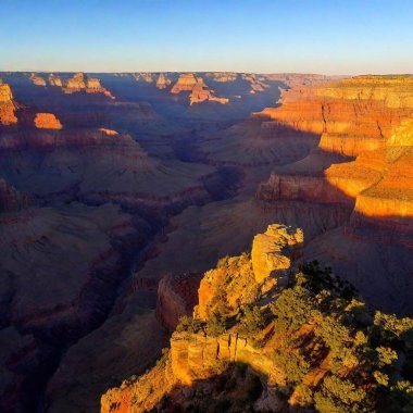 A full shot birds-eye-view photo of canyon scenery at sunrise, with soft focus highlighting the warm colors reflecting on the canyon walls and the deep shadows in the valley. clipart