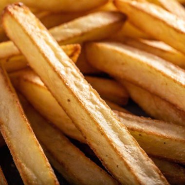 a macro shot from below a pile of crispy, golden French fries, looking up at the stack. Highlight the details of the texture, the golden color, and the glistening oil on the fries clipart