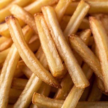 a macro shot from below a pile of crispy, golden French fries, looking up at the stack. Highlight the details of the texture, the golden color, and the glistening oil on the fries clipart