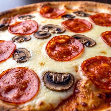 a macro image looking up at a giant slice of pizza loaded with toppings like pepperoni, mushrooms, and cheese. Focus on the textures of the melted cheese, the crisp edges of the crust, and the rich details of the toppings clipart