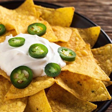 nachos with sour cream cheese and jalapeno jalapeno. closeup. clipart