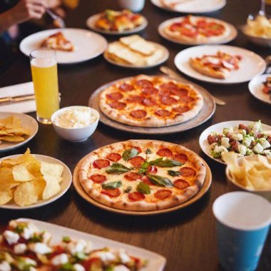 an extreme long shot of a party scene with a large table covered in a spread of junk food like pizza, wings, sliders, and various desserts. Show the full party setup including decorations and guests enjoying the food clipart