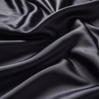 A high-resolution ultrarealistic image captures the exquisite detail of black silk fabric. The image is a photographic representation, emphasizing the smooth and luxurious texture of the silk. The fabric is draped elegantly, creating soft, flowing clipart