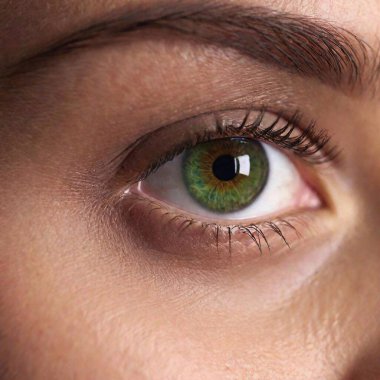 A high-resolution ultrarealistic image of a close-up segment of a person's face, captured with photographic precision. The image focuses on the left eye, showcasing a striking green iris with intricate details. The surrounding skin appears slightly clipart