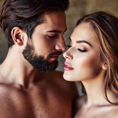 A high-resolution ultrarealistic photograph capturing an intimate, close-up moment. The image focuses on the faces and necks of a bearded man and a woman with delicate, soft skin. The man gently holds the woman's chin with his thumb and forefinger clipart