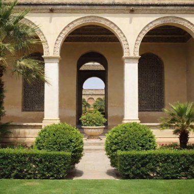 A high-resolution photo capturing the grandeur of an ancient, intricately designed palace and its lush gardens. The image features a detailed stone facade with carved arches and vibrant orange and blue accents. Tall, elegant palm trees stretch clipart