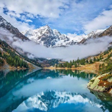 A high-resolution ultrarealistic image captures a breathtaking alpine landscape, rendered in photographic quality. The scene features a tranquil turquoise lake with crystal-clear water mirroring the rugged, snow-capped mountains in the background clipart