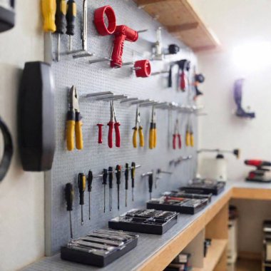 A high-resolution ultrarealistic photo of a meticulously organized workshop with a wide array of tools displayed on a pegboard and shelves. The image showcases a variety of hand tools like screwdrivers, pliers, wrenches, measuring tape, and levels clipart