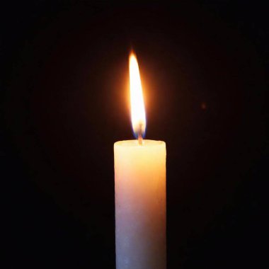 A high-resolution ultrarealistic image capturing the serene glow of a single candle. The image showcases a close-up of an ivory candle with a burning wick, producing a soft, steady flame. The flame exhibits a gradient of colors ranging from deep clipart