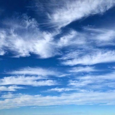 A high-resolution digital photograph of a bright, clear blue sky scattered with fluffy white clouds. The clouds vary in size and are spread sporadically throughout the vibrant azure expanse. The lighting is natural, emphasizing the crispness and clipart