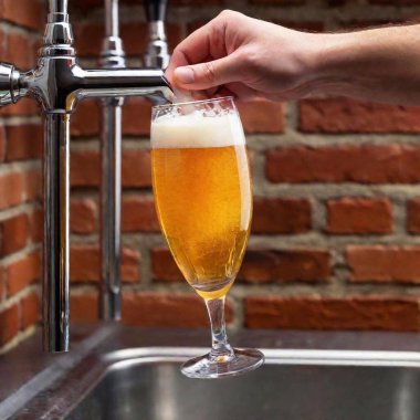 A high-resolution ultrarealistic image showcases a close-up scene of a bartender pouring a golden beer into a glass from a stainless steel tap. The image captures the splashing foam and shimmering liquid as the glass fills up. The bartender's hand clipart