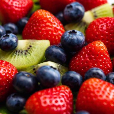 extreme close-up of a vibrant fruit platter with an assortment of fruits like strawberries, blueberries, and kiwi, with rack focus highlighting one fruit while softly blurring the rest clipart