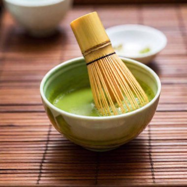 matcha green tea in bamboo bowl on wooden table. clipart