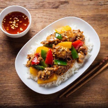 Sweet and Sour Pork: A flatlay that highlights a colorful plate of sweet and sour pork, garnished with pineapple and bell peppers, accompanied by steamed rice and a small bowl of soy sauce. clipart