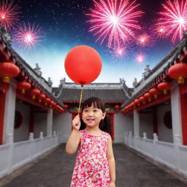 Chinese little girl with red balloon standing  against traditional Chinese garden and sky with fireworks at night clipart