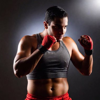 young boxer with boxing gloves posing on dark background clipart