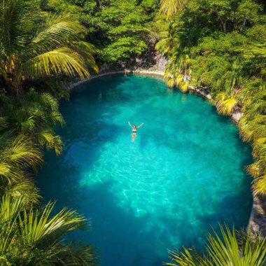 woman swimming in the middle of beautiful tropical pool clipart