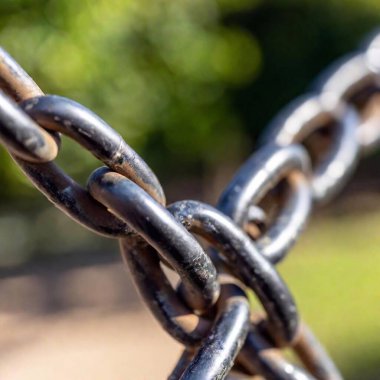 Macro of a chain links, focusing on the metal texture and wear. clipart