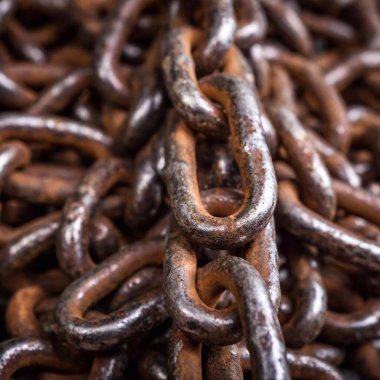 Macro of a steel chain, highlighting the worn metal and small imperfections. clipart