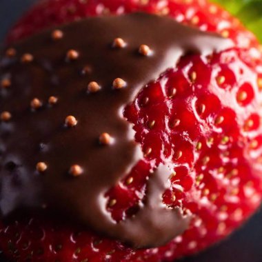 Close-up of a chocolate-covered strawberry with visible seeds. clipart