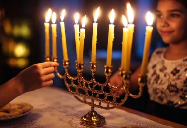 A point-of-view shot of a young girl's hands delicately arranging candles in the menorah, her eyes full of focus and excitement. clipart