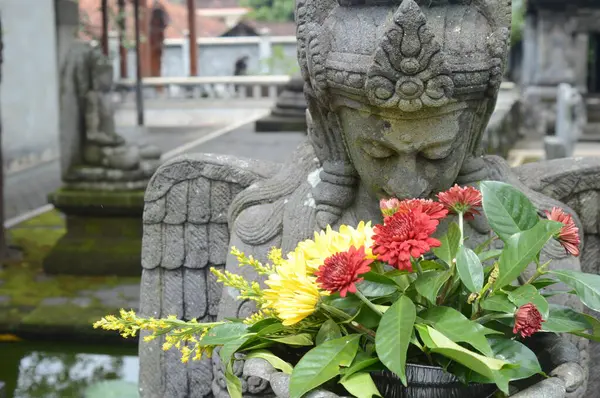 Bahçesinde çiçekler olan güzel Buda heykeli, bali, Endonezya.