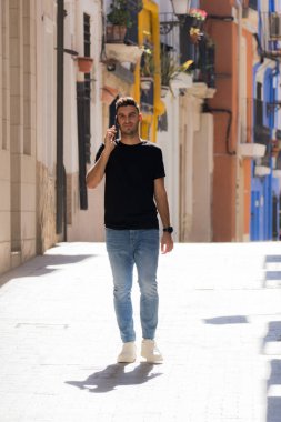 Genç adam Santa Cruz mahallesini ziyaret ediyor ve Alicia caddelerinde yürüyor.