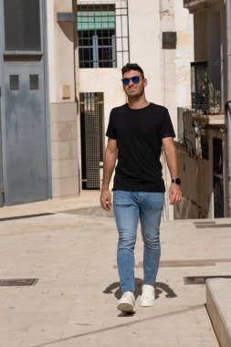 Genç adam Santa Cruz mahallesini ziyaret ediyor ve Alicia caddelerinde yürüyor.