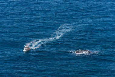 Uçurumun kenarından küçük bir tekne geçiyor.