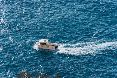 Uçurumun kenarından küçük bir tekne geçiyor.