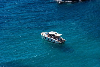 Turkuaz bir körfeze demir atmış bir zevk teknesi.