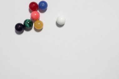 Beyaz arkaplanlı renkli boncuklar.