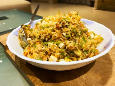 Kızarmış sebze pilavı ve süzme peynir lezzetli ve besleyici bir yemektir. Yumuşak, baharatlı pirinçle rengarenk, sotelenmiş sebzeler ve süzme peynirin altın sarısı küplerinin karışımıdır. 