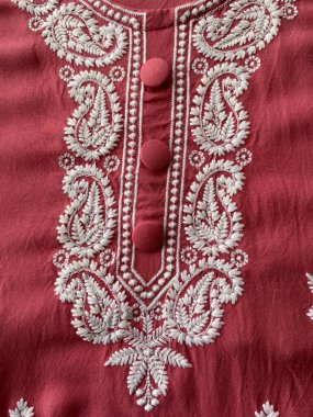 Kırmızı kumaşa işlemeli beyaz desenli iplik. 