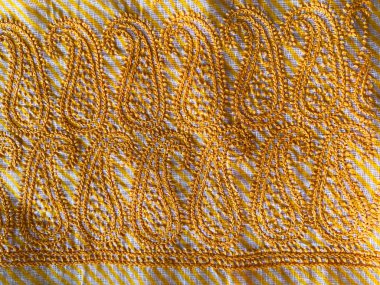 Bu tasarım, sarı iplikle işlenmiş, beyaz ve sarı lehriya pamuk kumaşında kusursuz bir sınır oluşturan, karmaşık desenli bir desen içerir.. 