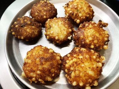 Kıtır kıtır kızartılmış sabudana pakodas bir tabakta dinleniyor, altın ve çıtır, Hint oruç günleri için mükemmel.. 