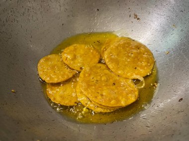 Derin bir tavada kızgın yağ içinde cızırdayan Mathris 'in yüzeyleri altın ve çıtır çıtır olurken köpürüyor..