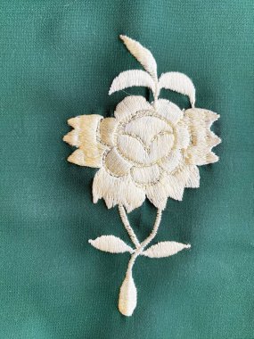 Beyaz çiçekli Parsi nakış motifi, geleneksel işçiliği modern cazibeyle harmanlayarak yeşil Georgette kumaşının zarafetini artırır..