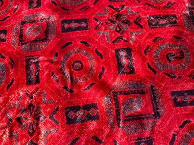 Geometrik Ajrakh blok baskısı, geleneksel sanatı lüks dokularla harmanlayarak, lüks kırmızı kadife kumaşı süsler.. 