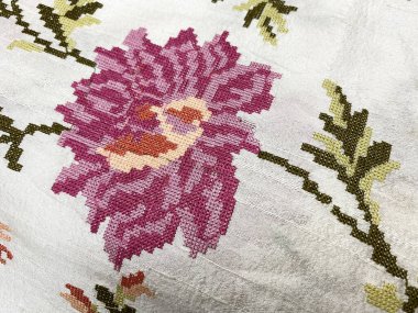 Narin, pembe ve manastır işlemeli bir çiçek ince işçiliği ve zarif tasarımı vurgulayan beyaz, ham ipekten, gösterişli, karmaşık bir nakış işi sergiliyor..