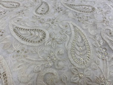 Beyaz Georgette sergilerine kendi kendine beyaz iplik nakışının yakın çekim görüntüsü desenleri karmaşık desenler, ince işçiliği vurguluyor..