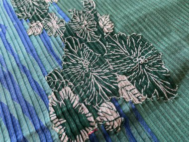 Kendi kendine dikilmiş, geometrik dalga baskılı kumaşın üzerine basılmış baskılı çiçek desenleri. 